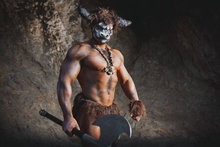 The bodyart man angry minotaur greek with axe in caveの写真素材