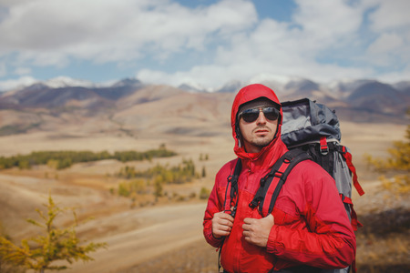 Adventure, travel, tourism, hike and people concept - man with backpack in mountainの写真素材