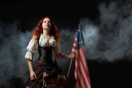 Girl in historic dress from United States Revolutionary War with flag. July 4th, Independence Day USA Concept Photo Compositionの写真素材