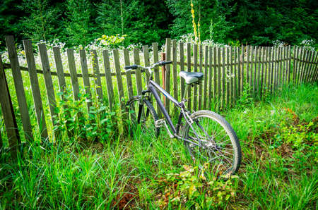 Bike sticking in the fence near the road in the natureの写真素材