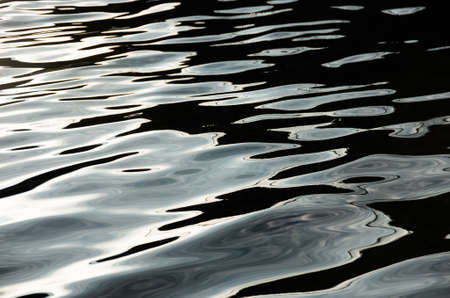Dark blue  black flowing river water surface, background photo textureの写真素材