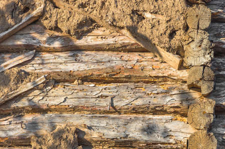 the wooden texture of the Adobe wall of the old abandoned houseの写真素材