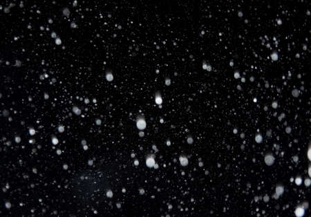 Winter background. falling snow isolated on pure black background