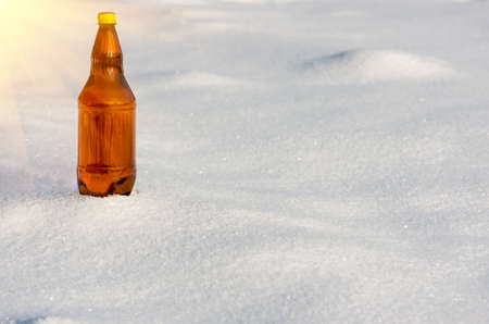 Beer in a plastic bottle in the snow in the winter