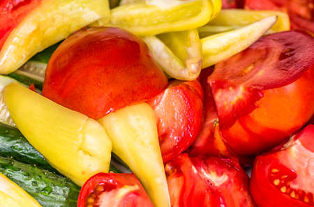 Organic fresh vegetables sliced tomatoes peppers cucumbersの写真素材