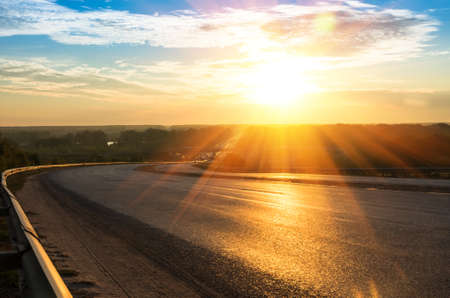 Picturesque landscape scene and sunrise above roadの写真素材