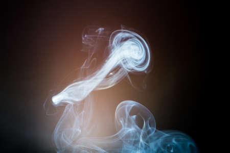 Beautiful cigarette smoke on a dark backgroundの写真素材