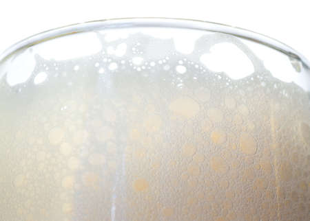 Beer foam in a glass on a white background closeの写真素材