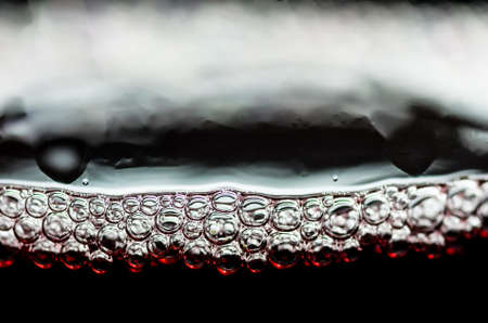 Bubbles in a glass of red wine closeの写真素材