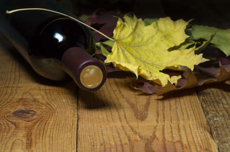 bottle of red wine lying on a wooden tableの写真素材