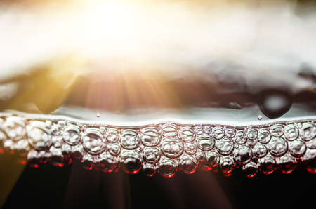 Bubbles in a glass of red wine closeの写真素材