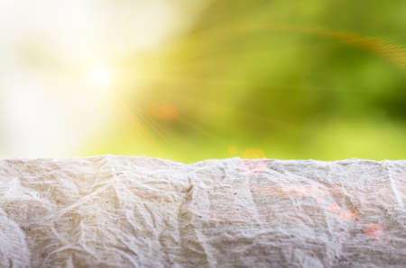 crumpled gray paper on the background of the solar green bokehの写真素材