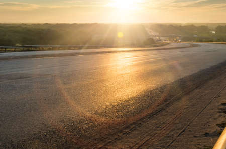 Paved road on the background of the rising sun