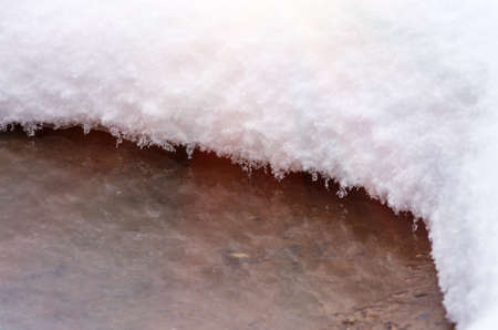 fluffy, powdery snow over the water close backgroundの写真素材