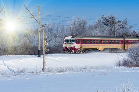 soviet electric train traveling on snow-covered terrain, sunny winter dayの写真素材