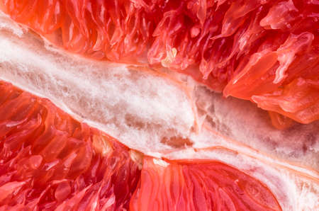 divided, juicy red inside grapefruit, closeup backgroundの写真素材