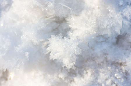 hoarfrost, ice and snow formed over the frozen water surface on the pond in winter in the sunlight....