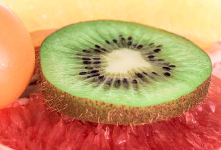 slice sliced kiwi lying on grapefruit, close-up. fruit background