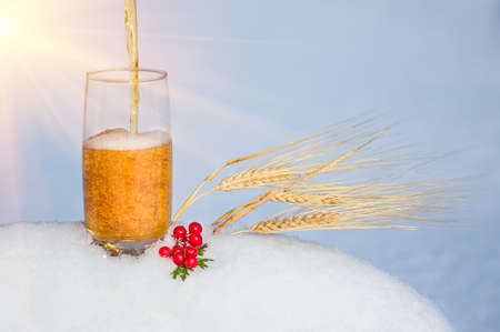 light beer in the snow with ears of wheat. winter backgroundの写真素材