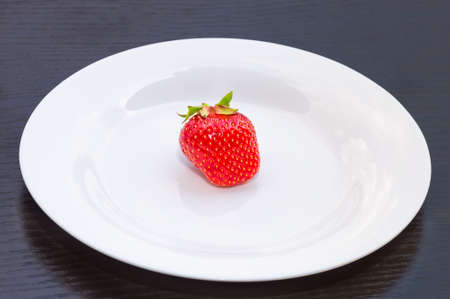 fresh ripe red organic strawberries closeup on a white plate, backgroundの写真素材