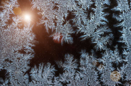 Ice patterns on glass on Christmas Eve. winter backgroundの写真素材