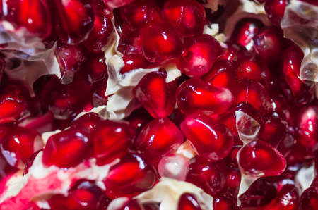 Fresh ripe pomegranate seeds with partitions closeup backgroundの写真素材