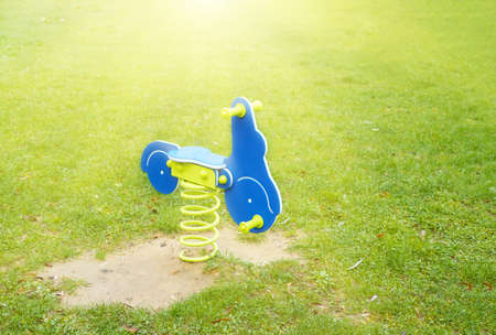blue motorcycle on the green grassy lawn, child's swing on a steel spring