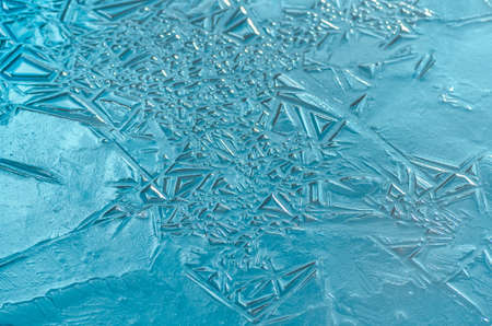 The texture of the frozen blue ice in the lake, closeup, winter backgroundの写真素材