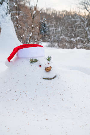 Cheerful snowdrift, snowman, in in christmas hat, in anticipation of waiting for Christmas holidays...