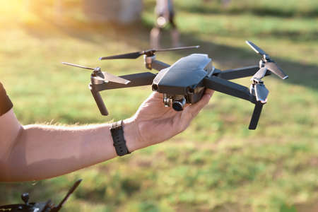 drone copter in hand on sky background. Remote controlled copter with digital camera in the hand. Closeup. New tool for aerial photo and video.の写真素材