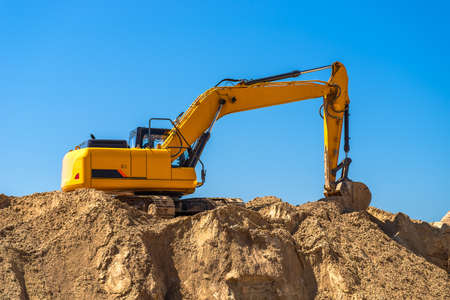 An industrial excavator closeup develops in a sandpit quarry. Industry, technology, mining. Heavy...