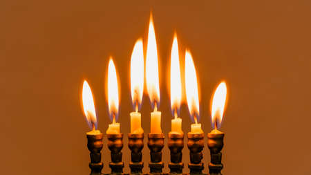 Hanukkah menorah closeup with burning candles for holiday card background. Retro old style hanukkah...