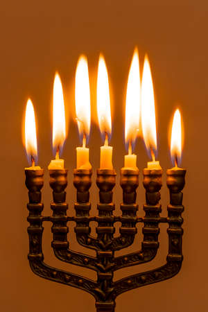 Hanukkah menorah closeup with burning candles for holiday card background. Retro old style hanukkah holidayの写真素材
