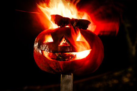Halloween pumpkin fire smile and scary eyes for party night. View of scary Halloween pumpkin with...
