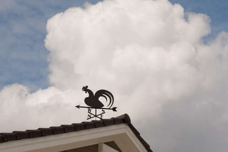 Weathervane with cock above an arrow and the four cardinal points North East West Southの写真素材