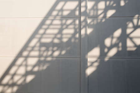 Shadows of house roof beam on the fence.の写真素材