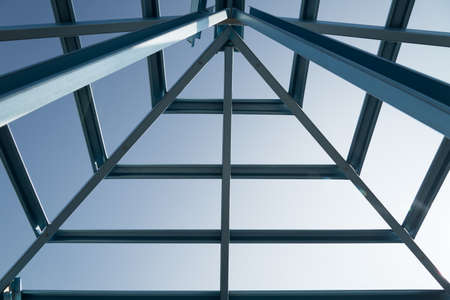 Structure of steel roof frame for building construction on sky background.の写真素材
