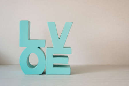 Green wooden letters forming word LOVE putting on wooden background.の写真素材