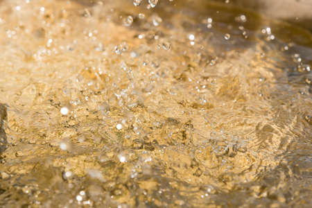Blurred motion of water splash on yellow background.の写真素材