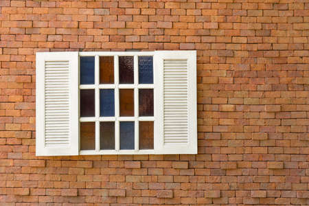 Old red brick wall with white window.の写真素材