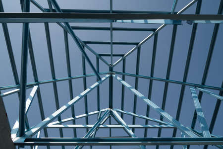 Structure of steel roof frame for building construction isolated on blue sky background.の写真素材