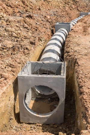 Concrete drainage pipe and manhole on construction site.