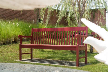 Red bench in a park on summertime.の写真素材