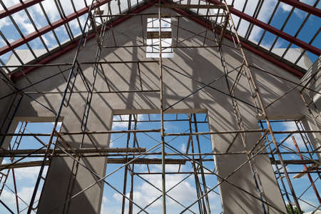House under construction with a scaffolding platforms for work in progress.