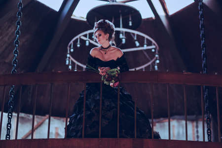 Mysterious woman dressed in gothic dress posing in ruined buildingの写真素材