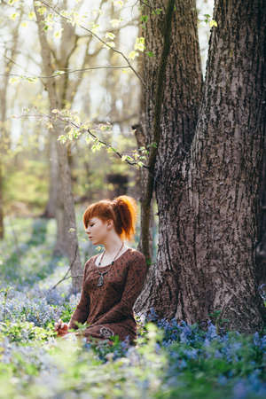 Beautiful young woman in the forest with spring flowersの写真素材