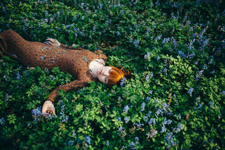 Beautiful young woman in the forest with spring flowersの写真素材