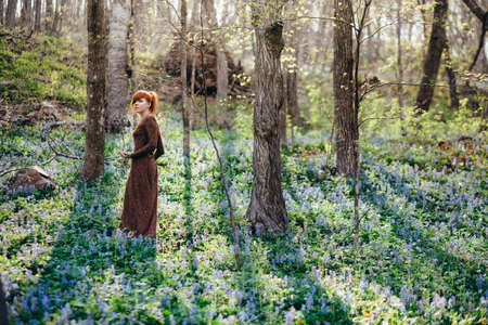 Beautiful young woman in the forest with spring flowersの写真素材