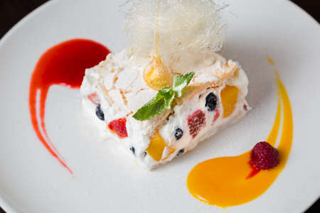 Creamy cheesecake decorated with berries on white plate