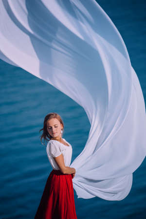 Beautiful Girl With White fabric on sea backgroundの写真素材